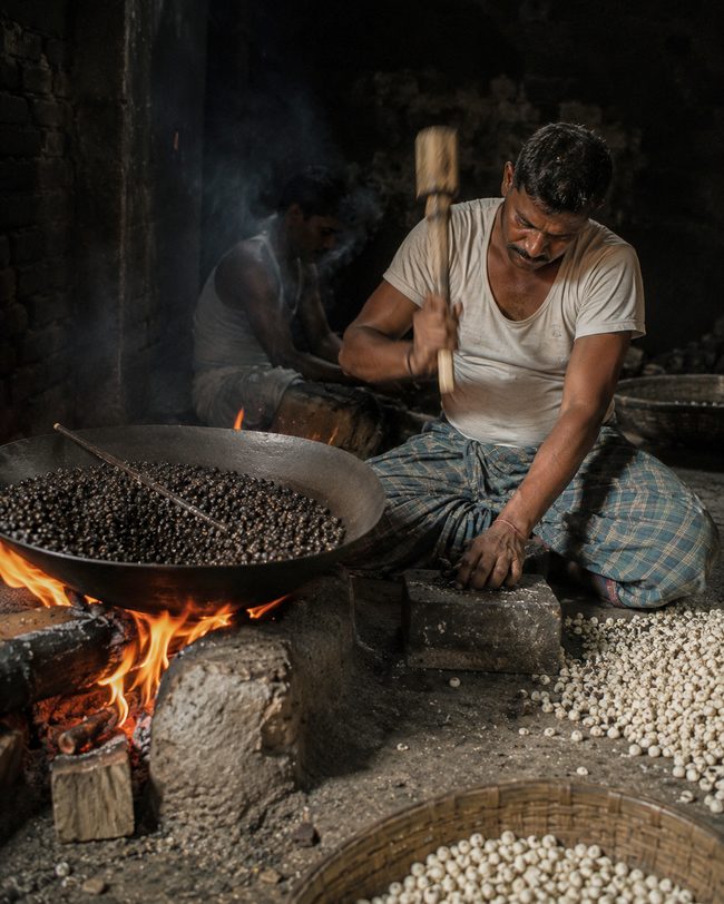 Popping fox nut in an iron pan